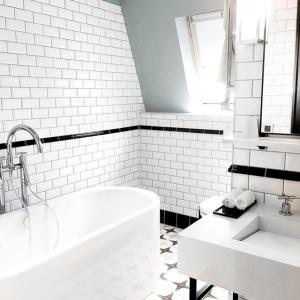 La salle de bains blanche est pourvue d'une baignoire et d'un lavabo. dans l'établissement Hôtel Adèle & Jules, à Paris