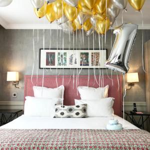 a bedroom with a bed with balloons above it at Hôtel Adèle & Jules in Paris