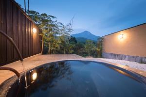 a swimming pool with a view of a mountain at Ikkoten in Yufu