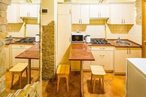 una cocina con armarios blancos y mesas y sillas de madera. en Apartment Zhyzhky 9, en Leópolis