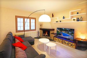 sala de estar con sofá, TV y chimenea en Casa Rural Els Pins, en Sant Marçal