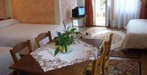 Zimmer mit einem Tisch und Stühlen sowie einem Schlafzimmer in der Unterkunft Hotel de France in Montbéliard