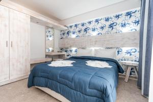 a bedroom with a blue bed and blue and white wallpaper at The Elegant Apartments in Pefkari