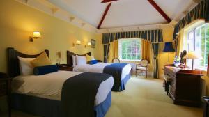 a hotel room with two beds and a window at Killeen House Hotel in Killarney