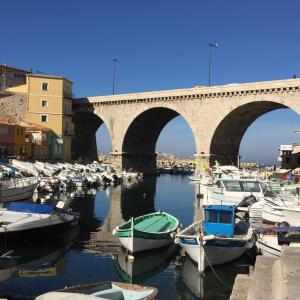 a group of boats in a harbor with a bridge at Cabanon de pêcheur in Marseille