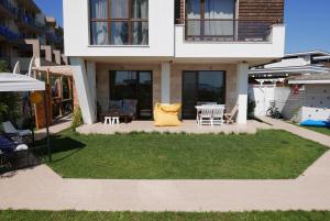 une maison avec une cour dotée d'une table et de chaises dans l'établissement Apolonia Resort Apartments, à Sozopol