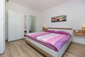 a white bedroom with a purple bed and a mirror at Villa Luka Nedešćina in Nedeščina +30 photos