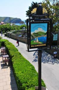 a sign on a pole next to a sidewalk at Lulworth Cove Inn in Lulworth Cove
