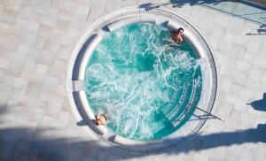 two people swimming in a pool with water in it at Louis St. Elias Resort & Waterpark in Protaras