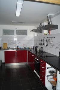 ヨセフーフ・ドゥールにあるChata Pekloのキッチン(赤いキャビネット、黒いカウンタートップ付)