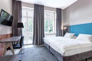 a hotel room with a large bed and a desk at Hotel Kaliski in Słubice