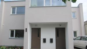 a white house with two doors and a car at Tamme Flint in Tartu