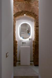 een badkamer met een witte wastafel en een stenen muur bij Casa Thiele alla Signoria in Florence