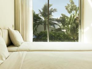 una cama en una habitación con una ventana grande en Refillnow! Hostel, en Bangkok 42 fotos más