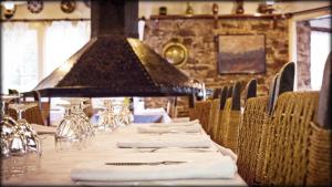 een lange tafel met witte servetten en stoelen in een restaurant bij Hostal l'Avet Blau in Santa Fe de Montseny