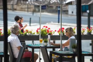two people sitting at a table in a restaurant at Vila Galé Estoril in Estoril
