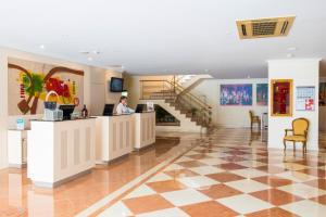 a woman sitting at a counter in a lobby at Vila Galé Estoril in Estoril