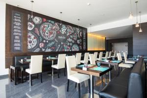 a restaurant with tables and white chairs and a chalkboard at Vila Galé Estoril in Estoril