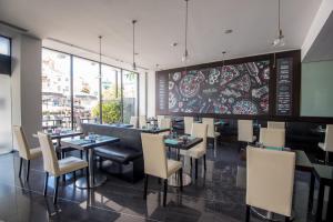 a restaurant with tables and chairs and a large wall of windows at Vila Galé Estoril in Estoril