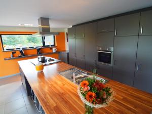 cocina con encimera de madera y jarrón de flores en Luxurious Holiday Home in Profondeville Ardennes, en Bois-de-Villers