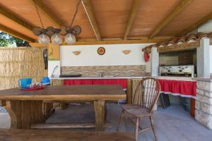 an outdoor kitchen with a wooden table and chair at Villa Luka Nedešćina in Nedeščina