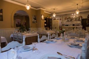 un comedor con mesas blancas y sillas blancas en Alojamientos Turísticos Biarritz, en Fuenteheridos