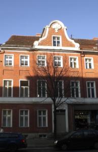 duży budynek z czerwonej cegły z zegarem w obiekcie Altstadt-Pension-Potsdam w Poczdamie