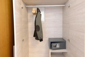 a room with a tv and a coat hanging on a wall at BB Venice Cinzias' in Marghera