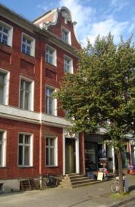 a red brick building with a tree in front of it at Altstadt-Pension-Potsdam in Potsdam