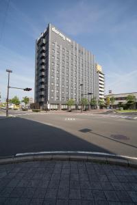 un grand bâtiment au coin d'une rue dans l'établissement Dormy Inn Izumo, à Izumo