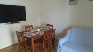 a small dining room table with chairs and a couch at Apartment Quiet Getaway in Koromačno