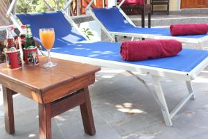 une table, des chaises et un verre de jus d'orange sur la terrasse dans l'établissement Rimlay Park Resort, à Phatthalung