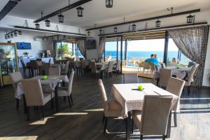 a restaurant with tables and chairs and a view of the ocean at Nautilus Apartments in Dobra Voda