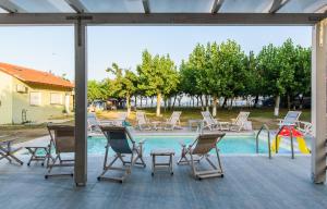 a group of chairs sitting around a swimming pool at Camping Valti Houses in Sarti