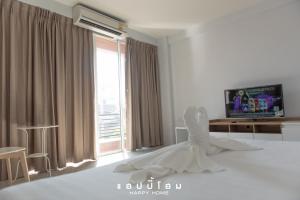 a white wedding dress sitting on a bed in front of a window at Happy Home in Ratchaburi