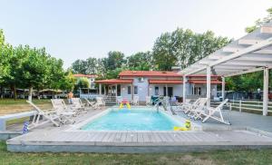 a swimming pool with chairs and a pool noodle in a yard at Camping Valti Houses in Sarti