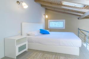 a white bedroom with a bed and a desk at Camping Valti Houses in Sarti