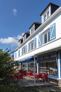 a row of red chairs in front of a building at Hôtel Les Gens De Mer Lorient by Popinns in Lorient