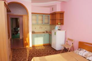 a small kitchen with a refrigerator and a table at Sedmoye Nebo Hotel in Utes