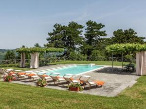 a swimming pool with chairs and a group ofitures at Expansive Villa in Tredozio Tuscany with Panoramic Views in Tredozio