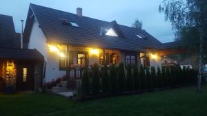 uma casa com uma cerca em frente à noite em Chalupa MATEJKO em Liptovský Mikuláš