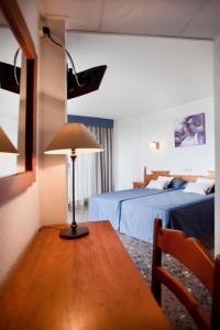 a room with two beds and a table with a lamp at Sunday's Beach in Peniscola