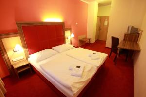 ein Hotelzimmer mit einem Bett mit zwei Handtüchern darauf in der Unterkunft Hotel U Divadla in Znojmo