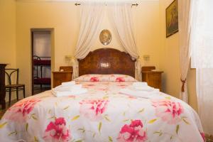 a bedroom with a large bed with pink flowers on it at Giulia e Pietro - Marettimo Apartments in Marettimo