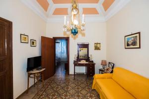 a living room with a yellow couch and a chandelier at Giulia e Pietro - Marettimo Apartments in Marettimo