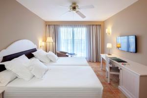 
a hotel room with two beds and two lamps at Occidental Isla Cristina in Isla Cristina
