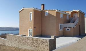 een huis met een stenen muur naast een gebouw bij Apartment in Rtina/Zadar Riviera 8160 in Miočić