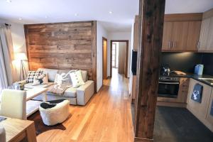 a living room with a couch and a kitchen at Steinberghaus Apartments in Leogang