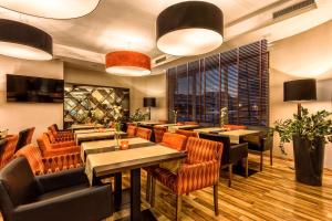 restauracja ze stołami i krzesłami oraz dużym oknem w obiekcie Hotel Kaliski w Słubicach