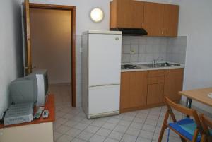 a kitchen with a white refrigerator and a television at Apartment Privlaka 2 in Privlaka